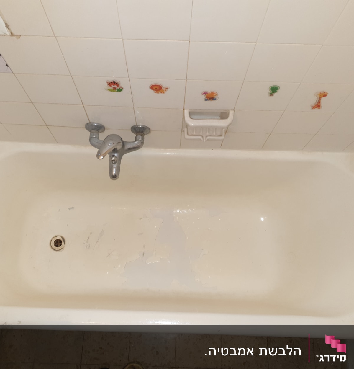 אמבטיה לבנה עם ברז כסוף ואריחים מעוטרים